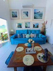 un soggiorno con divano blu e tavolo di Lofts do Morro Magico a Búzios