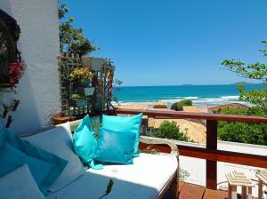 un sofá en un balcón con vistas al océano en Lofts do Morro Magico en Búzios
