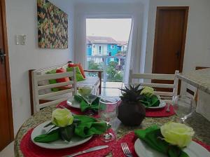 una mesa de comedor con platos de comida. en Ap (Flat) Taperapuã Porto Seguro, en Porto Seguro