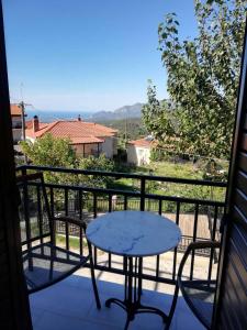 eine Terrasse mit einem Tisch und Stühlen auf dem Balkon in der Unterkunft Giota's Gasthaus in Zakharo