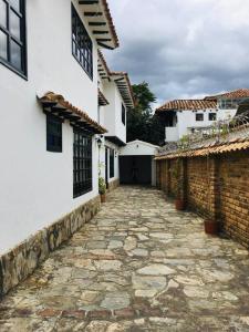 une passerelle en pierre entre deux maisons blanches et un bâtiment dans l'établissement Casa Central a 4 cuadras de la Plaza, à Villa de Leyva