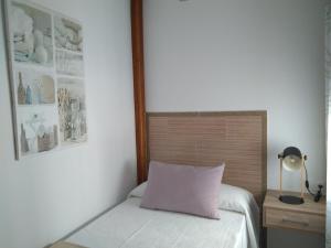 オリベンサにあるApartamento Rosa de Alejandríaのベッドルーム1室(紫色の枕が付いたベッド1台付)