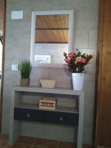 una consola con flores y un espejo en Apartamento Rosa de Alejandría, en Olivenza