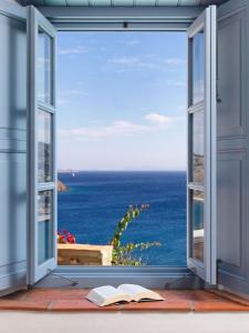 an open window with an open book on the floor at Patmos Eye Traditional Luxury Villas in Skala