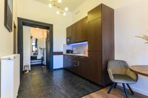 a kitchen with wooden cabinets and a table and a chair at Uptown Deluxe in Braşov