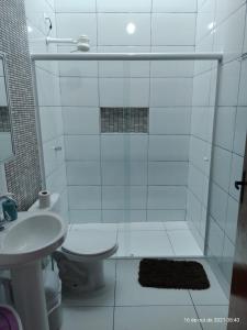 Un baño con ducha, inodoro y lavabo. en Casa Nova com Piscina 3 quartos, en Guaratuba 24 fotos más