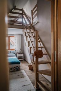 a wooden staircase in a room with a bed at Apartament nad Potokiem in Witów