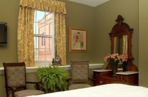 a bedroom with a bed and a mirror and a window at National Hotel Jackson in Jackson