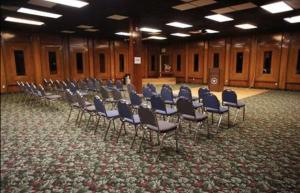 a row of chairs in a large room with a stage at OK Hotel in Oklahoma City