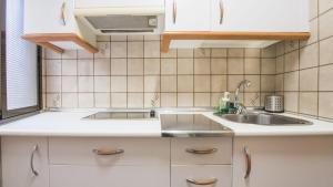 Una cocina con gabinetes blancos y un fregadero. en La casa de los Becquer by Toledo AP, en Toledo 64 fotos más