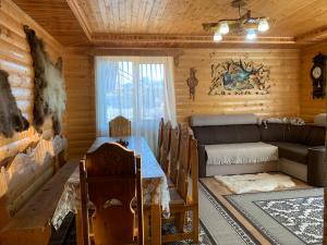 a living room with a couch and a table in a log cabin at Чорногора in Vorokhta