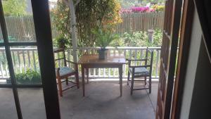 a table and two chairs on a porch with a table at Best Little Guest House new name is Beit Shalom Guest House in Oudtshoorn