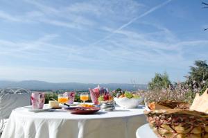 una mesa blanca con comida y bebidas en la parte superior en Le Mas Dauphinois, en Le Grand-Lemps
