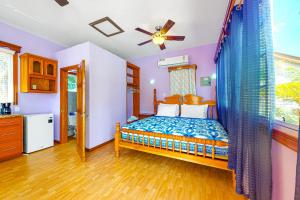 a bedroom with a bed and a window at Bella at Hummingbird Estate Gold Standard Certified in Dangriga