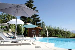 two chairs and umbrellas next to a swimming pool at Le Mas Dauphinois in Le Grand-Lemps