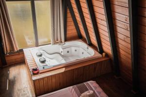 a bath tub in a room with a window at URUBICI - Cabana da Montanha in Mundo Novo