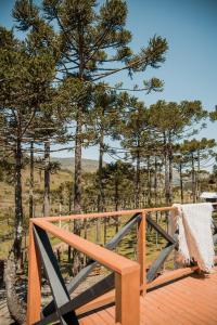 a wooden deck with a chair on top of it at URUBICI - Cabana da Montanha in Mundo Novo