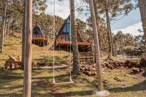 a tree house in the woods with a swing at URUBICI - Cabana da Montanha in Mundo Novo
