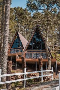 a log cabin in the woods with a fence at URUBICI - Cabana da Montanha in Mundo Novo
