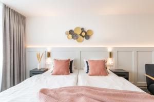 a bedroom with a large white bed with pink pillows at Hotel Bad Minden in Minden