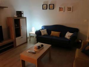 蓬費拉達的住宿－El 0tro Cuartín，客厅配有蓝色的沙发和茶几