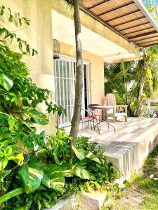 a porch of a house with a table and chairs at Cómodo y bello departamento cerca de la Zona hotelera y el ferry a Isla mujeres in Cancún
