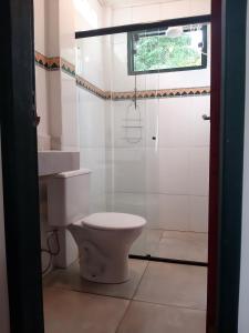 a bathroom with a toilet and a window at Charmoso studio em Tiradentes in Tiradentes