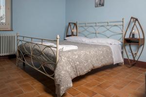 1 dormitorio con 1 cama con marco de metal en In Collegiata, en Foiano della Chiana