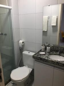 ein Badezimmer mit Toilette, Waschbecken und Spiegel in der Unterkunft Muro alto Condomínio Clube flat 211 in Porto De Galinhas + 8 Fotos