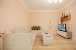 a living room with a white couch and a tv at Miku Apartment-Spectacular 1BD At Komuna e Parisit in Tirana