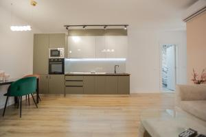 a living room with a kitchen and a couch at Miku Apartment-Spectacular 1BD At Komuna e Parisit in Tirana