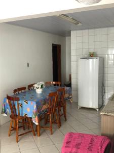 a kitchen with a table with chairs and a refrigerator at casa praia em bombinhas in Bombinhas