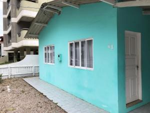 a blue building with a white door and windows at casa praia em bombinhas in Bombinhas