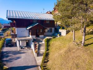 une maison sur une colline avec un vélo garé devant elle dans l'établissement Serpolet - Chalet 4 personnes - Sauna, à Leysin