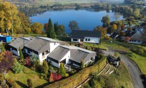 eine Luftansicht eines Hauses mit See in der Unterkunft Traumhaus am Maar in Schalkenmehren
