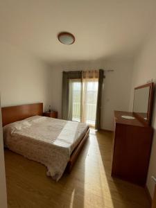 um quarto com uma cama, uma cómoda e uma janela em casa das Termas do Carvalhal em Carvalhal