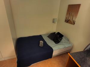 a small bedroom with a bed with a blue blanket at Vistula Oslo in Oslo
