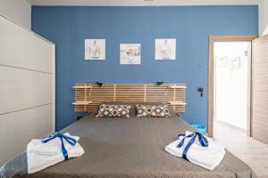 ein Schlafzimmer mit einem großen Bett mit blauen Wänden in der Unterkunft B&B Home Visit in Agrigento