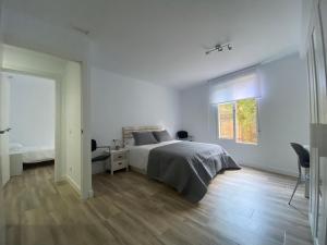 a white bedroom with a bed and a window at Cozy flat in La Petxina B in Valencia