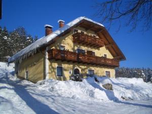 ein schneebedecktes Gebäude mit Schnee darauf in der Unterkunft Ferienhaus Huber in Bleiburg