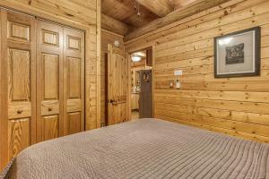 a bedroom with a bed in a wooden cabin at Sonshine By The Stream, Next To A Stream, 560 FREE tickets each paid day in Cosby