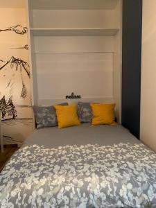 a bedroom with a bed with yellow pillows at Studio apartman OLAF in Jahorina