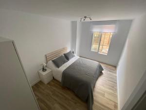 um quarto branco com uma cama e uma janela em Cozy flat in La Petxina_A em Valência