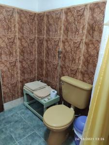 Un baño con inodoro y una pared de azulejos. en Iguazú Alojamiento "La casa", en Puerto Iguazú 10 fotos más