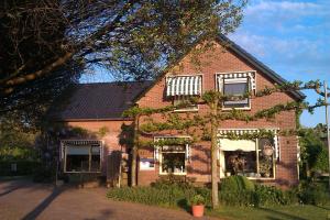 a red brick house with ivy growing on it at b&b de Vlinder in Hardenberg