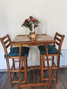 a wooden table with two chairs and a bottle of champagne at La bulle suspendue in Bassevelle
