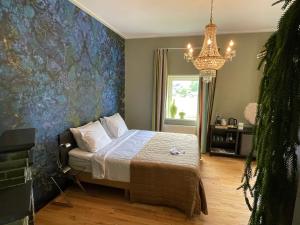 a bedroom with a bed and a chandelier at Villa Rozenhof in Almen