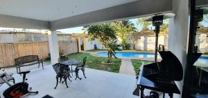 Un patio con mesa y sillas y una piscina. en Villa Parisienne Modern Guest house, en Ciudad del Cabo