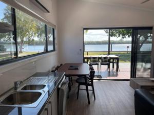 a kitchen with a table and a view of the water at Fishing Haven Holiday Park in Palmers Island