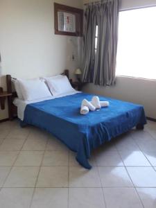 Un dormitorio con una cama azul con toallas. en Mirante Bela Vista, en Niterói 67 fotos más